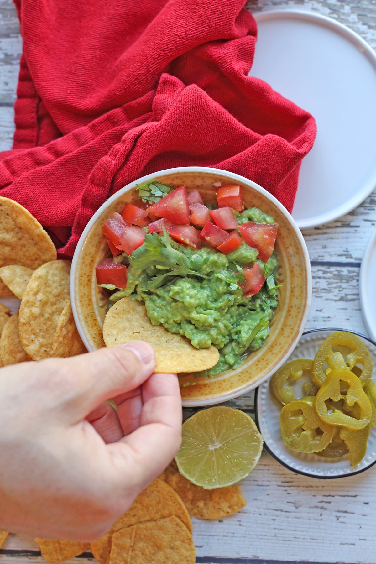 Tortilla chip being dipped into guacamole.