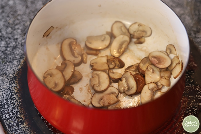 Mushrooms browning in soup pot.