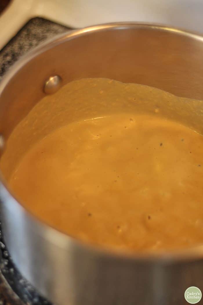 Cashew cheese sauce warming in a soup pot.