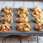 Stuffing muffins in muffin tin on table.