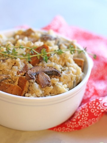 Close up vegan risotto with mushrooms, seitan sausage, and thyme.