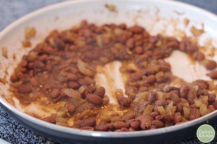 Pinto beans with onions and garlic in skillet.