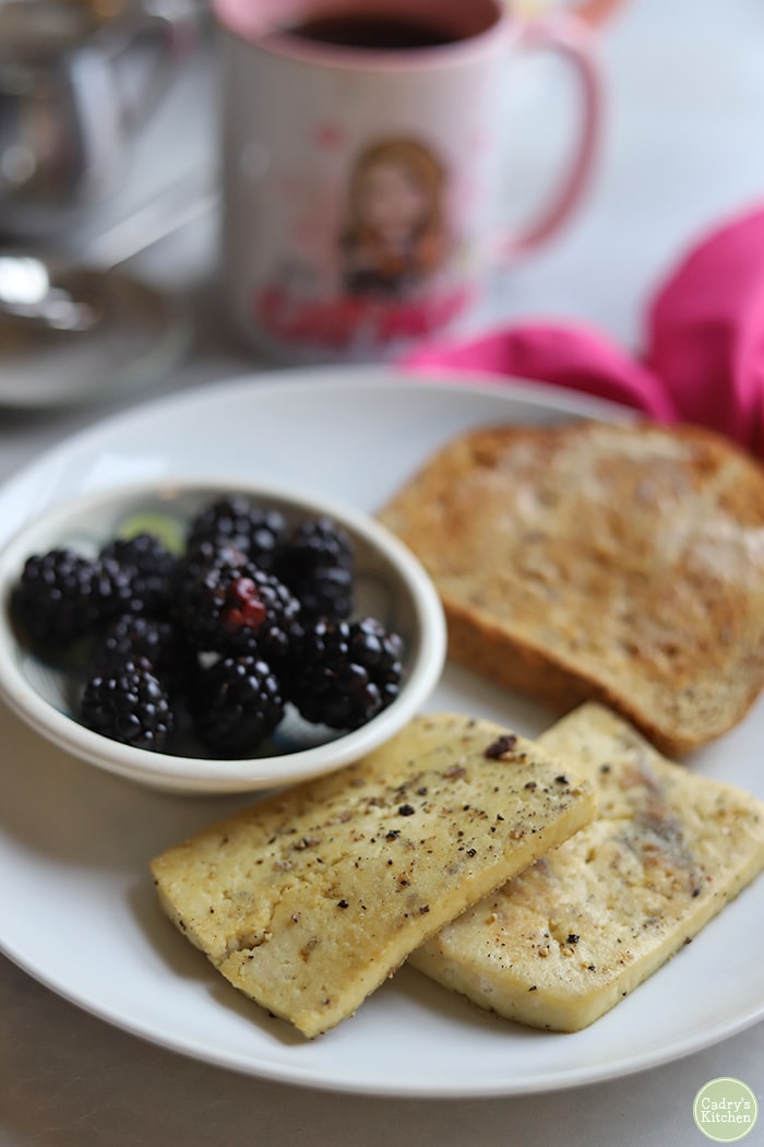 Slabs of eggy tofu laying on plate with toast and berries.