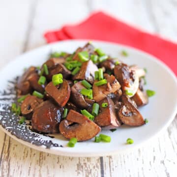 Red wine infused mushrooms on a white plate.
