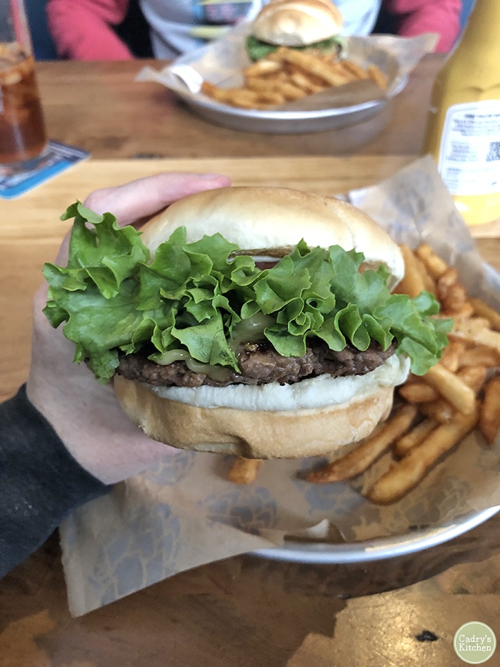 Hand holding Impossible Burger at 30 Hop in Coralville, Iowa.
