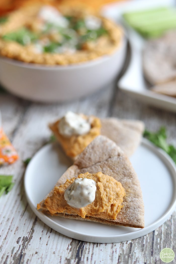 Spicy chickpea bean dip on pita chips with vegan blue cheese dressing.