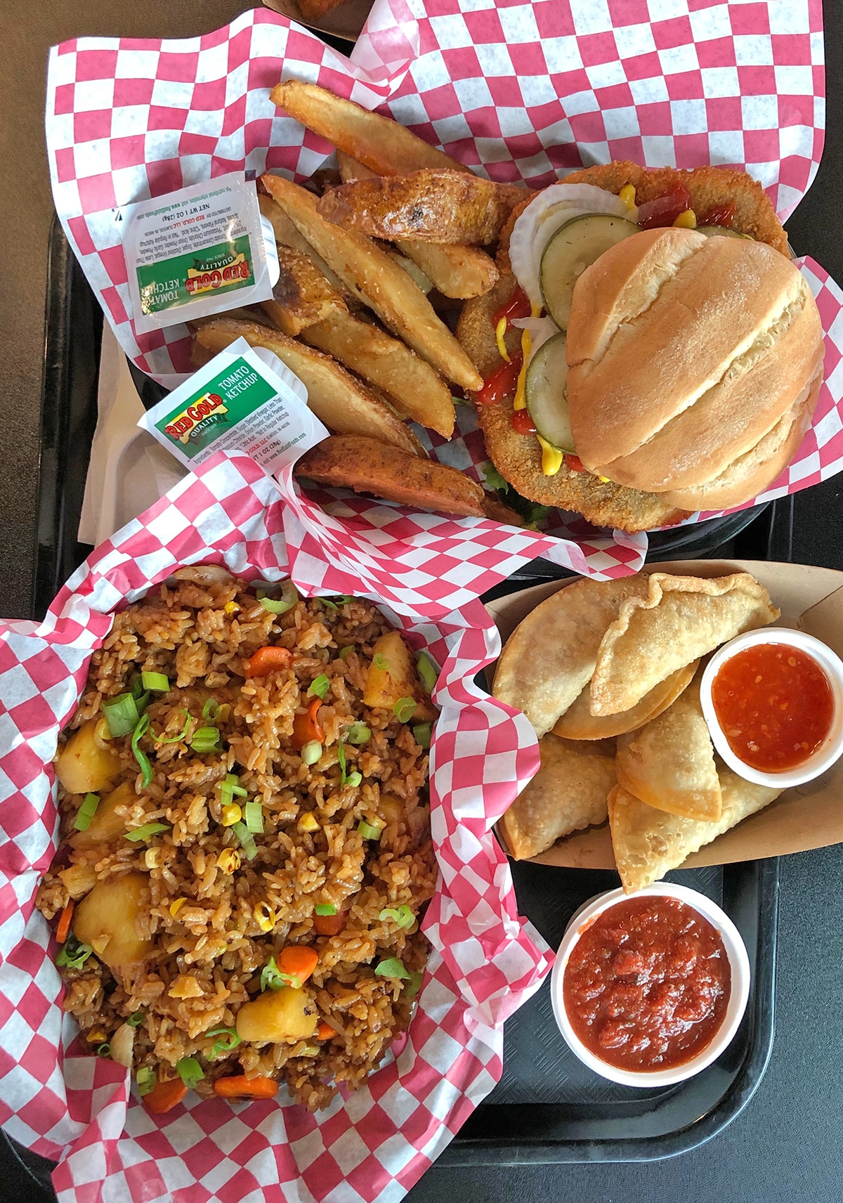 Overhead tray with vegan tenderloin, dumplings, and fried rice.