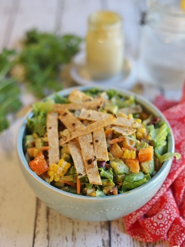 Southwestern salad in bowl with tortilla strips on top.