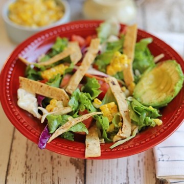 Bowl of southwest salad with crispy corn tortilla chips, and avocado.