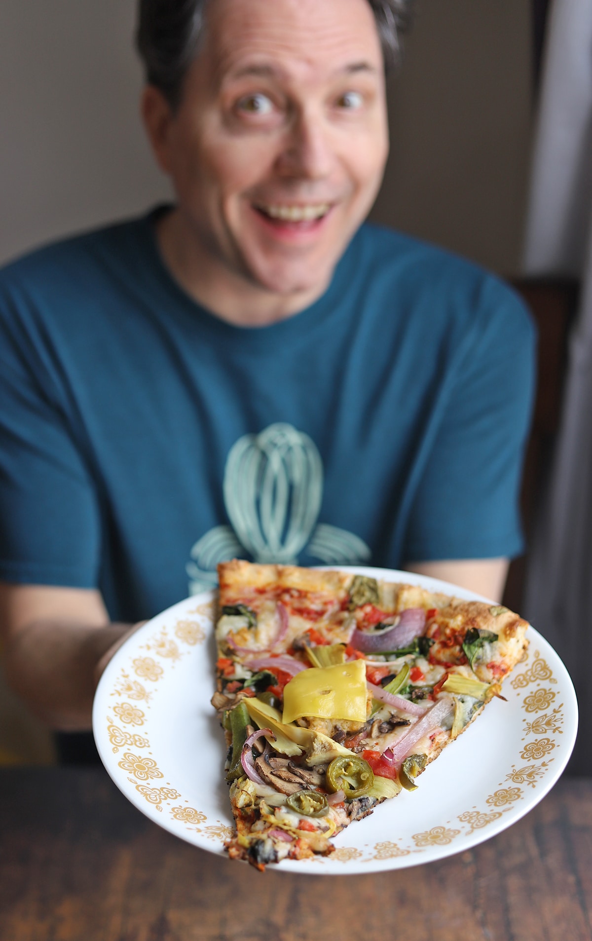 David holding a slice of Lopiez vegan pizza.