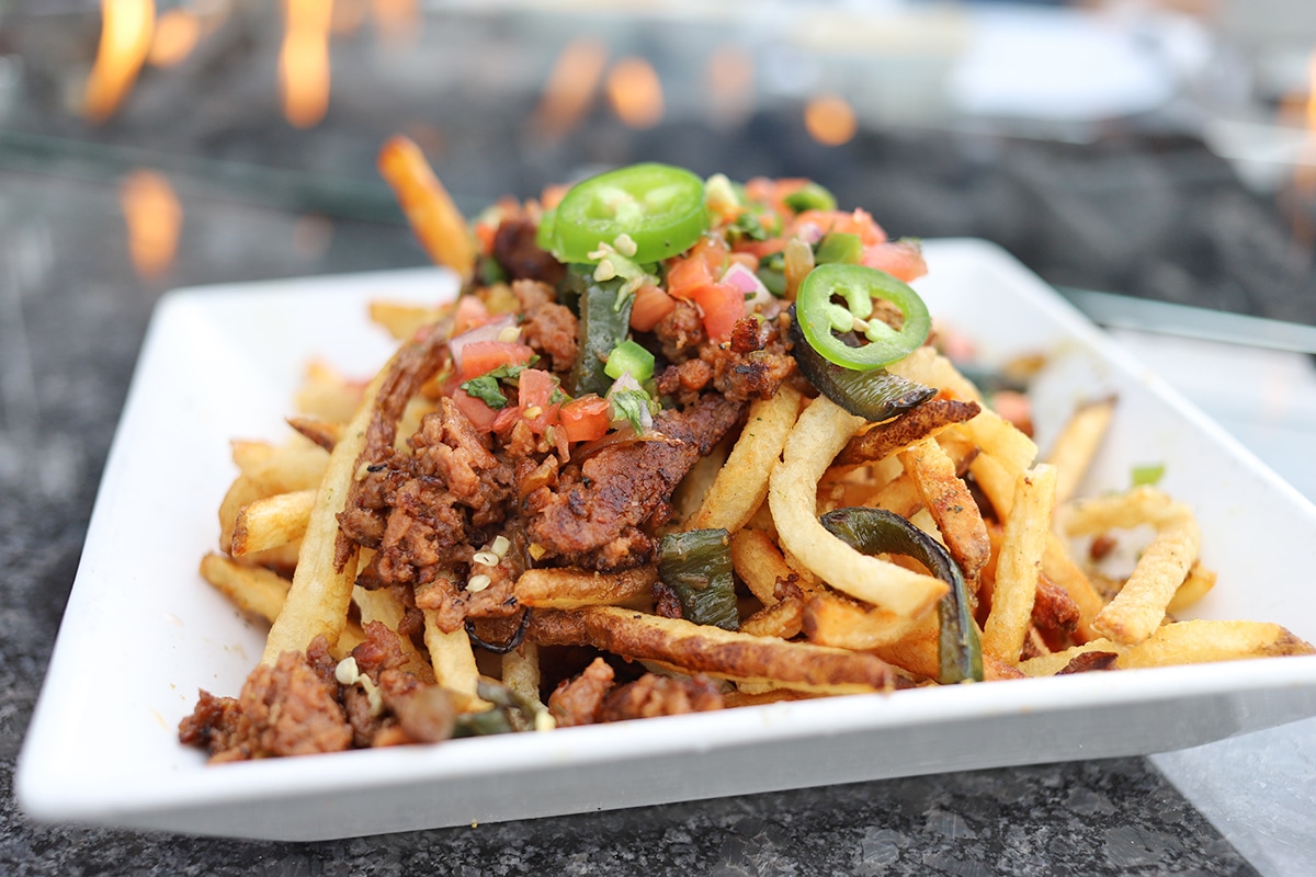 Fries piled with Beyond Meat, jalapeno peppers, and pico de gallo.