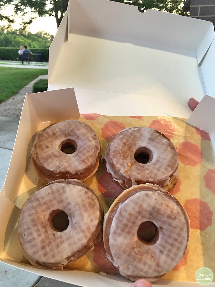 Four vegan glazed donuts in a box.