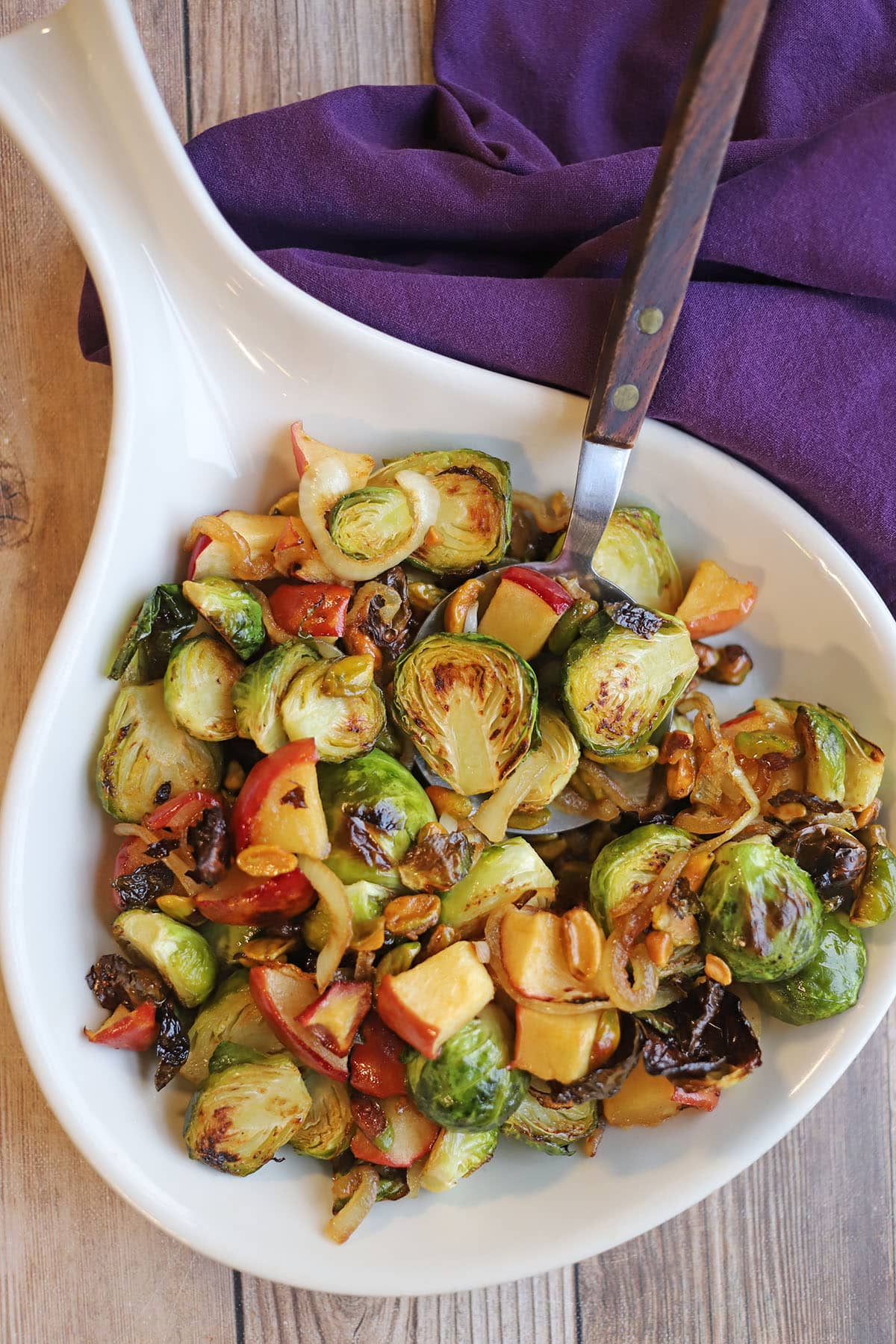 Platter with apples, caramelized onions, pistachios, and Brussels sprouts.