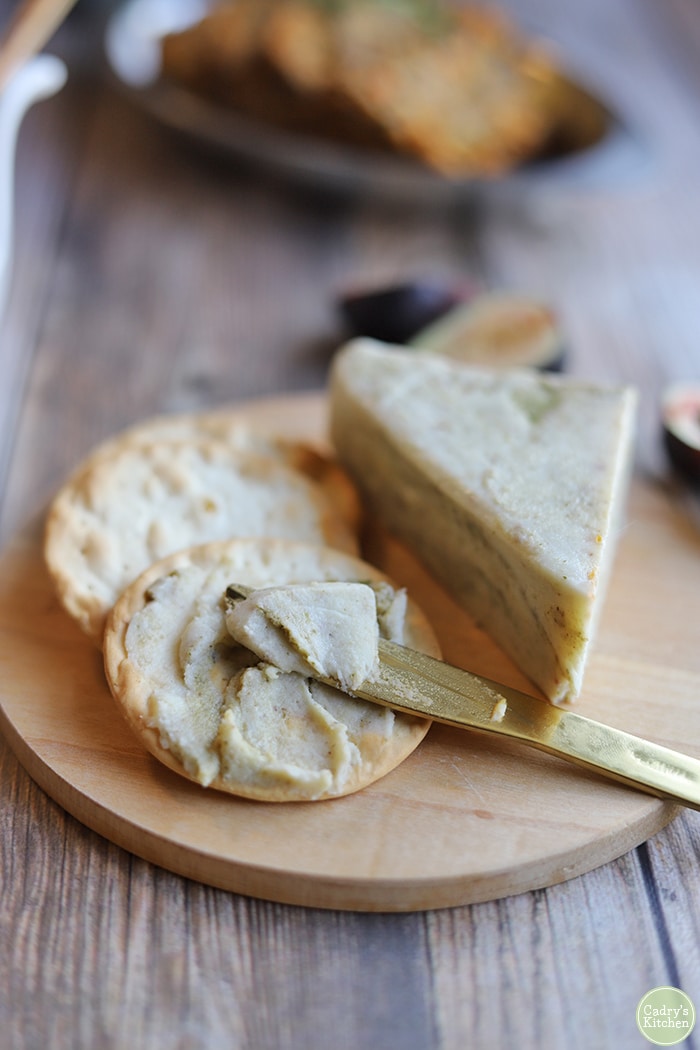 Pesto cheese with crackers on cheeseboard.