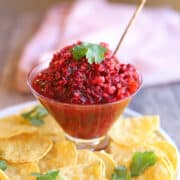 Cranberry salsa in bowl surrounded by tortilla chips.