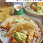 Text overlay: Vegan fish tacos. Two tacos on plate by chipotle crema.