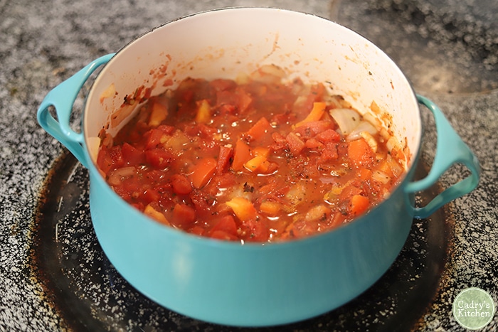 Tomato and bell pepper sauce in pot on stove.