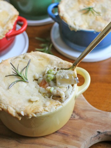 Pot pie in cocotte with spoon breaking into it.