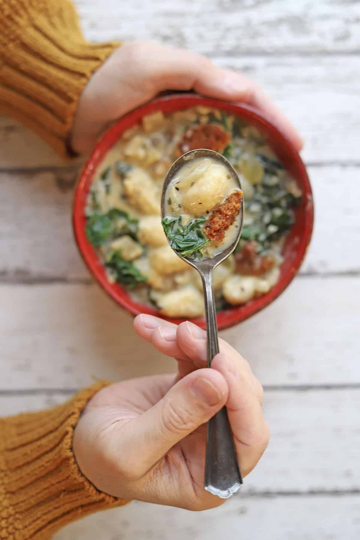 Spoon hovering over bowl of soup.