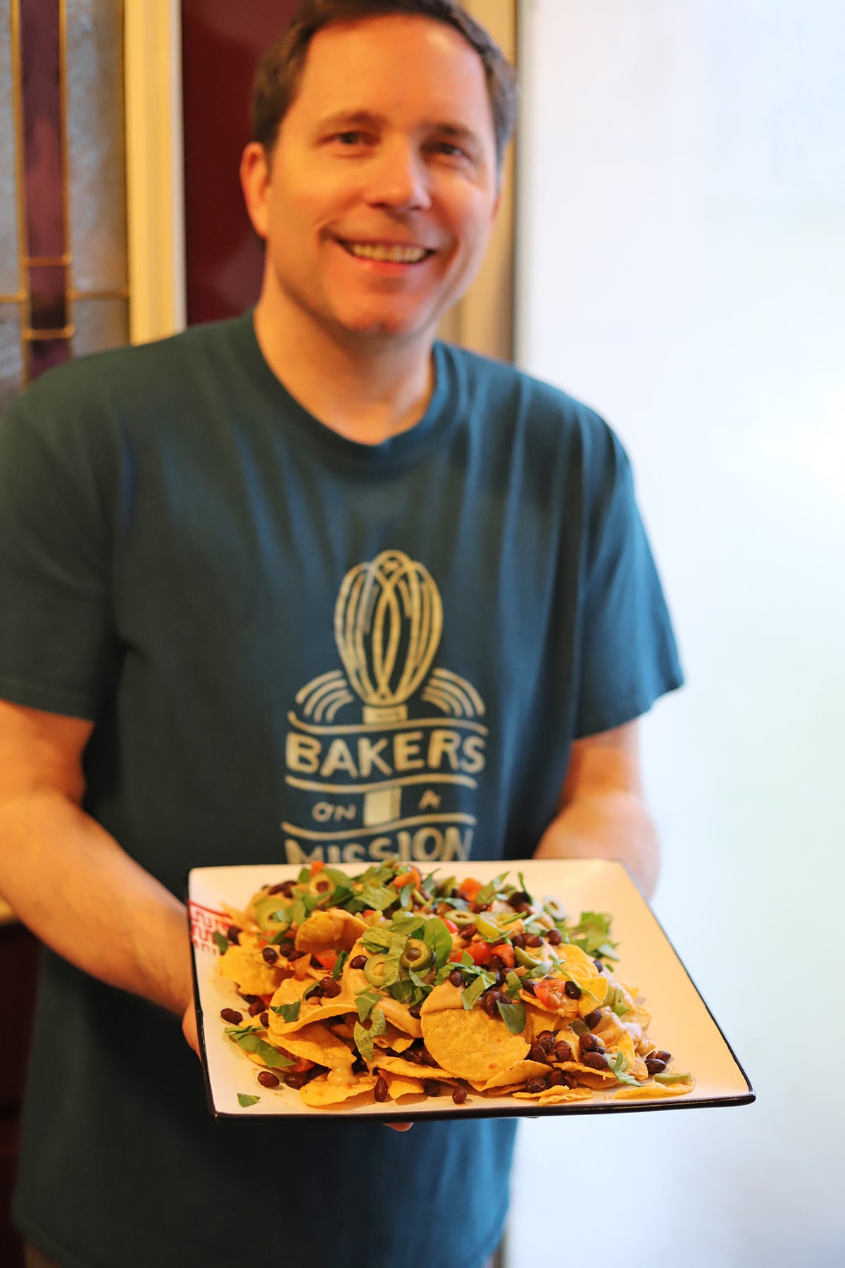 David holding platter of nachos.