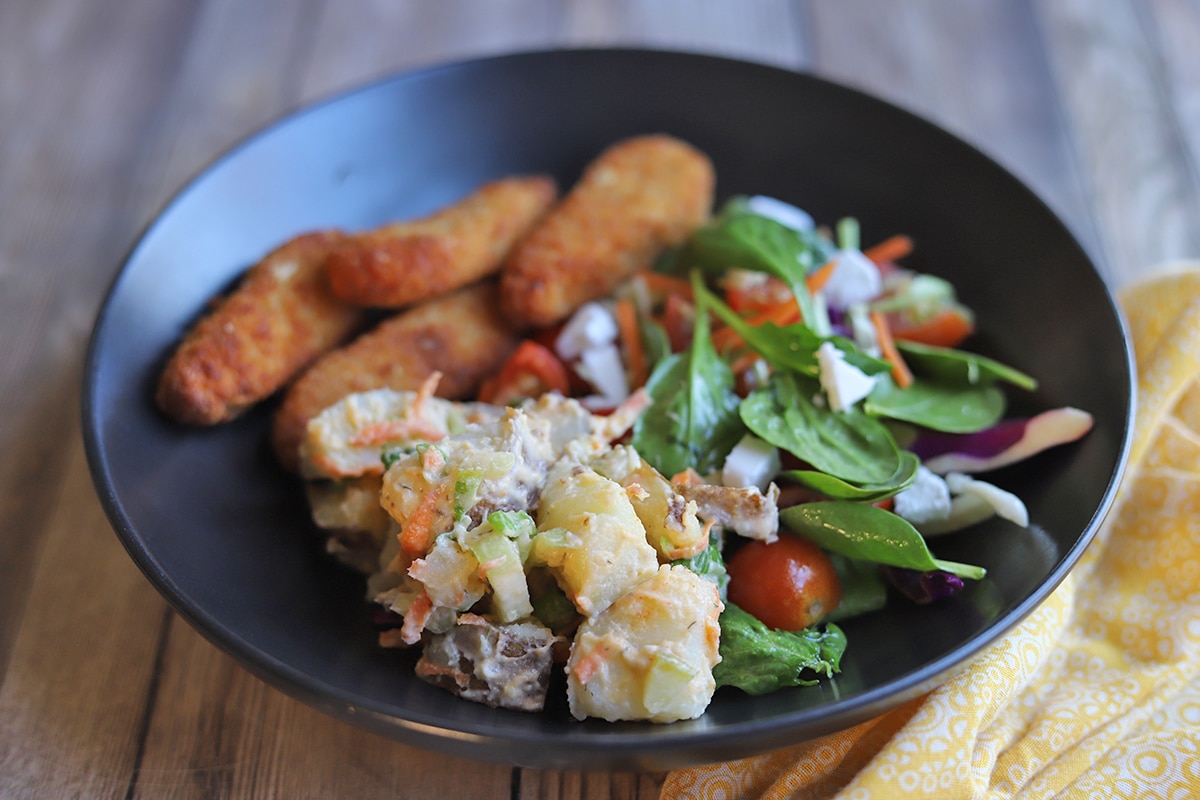 Potato salad with spinach and vegan chick'n strips.