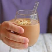 Hand holding a chocolate peanut butter smoothie.