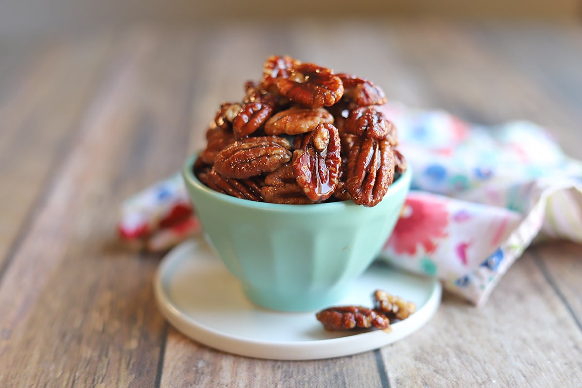 Candied pecans in blue bowl on table.