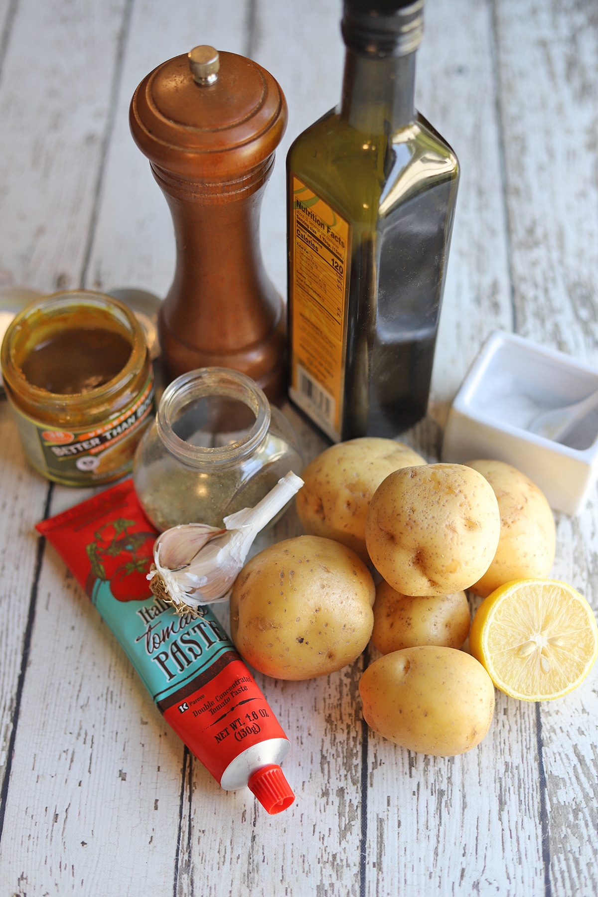 Ingredients for lemony potatoes: tomato paste, Yukon gold potatoes, salt, oregano, garlic, bouillon, pepper, and olive oil.