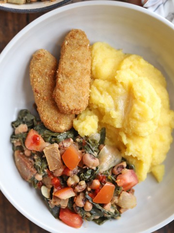Overhead bowl with polenta, vegan chick'n strips, and black-eyed peas with collard greens.