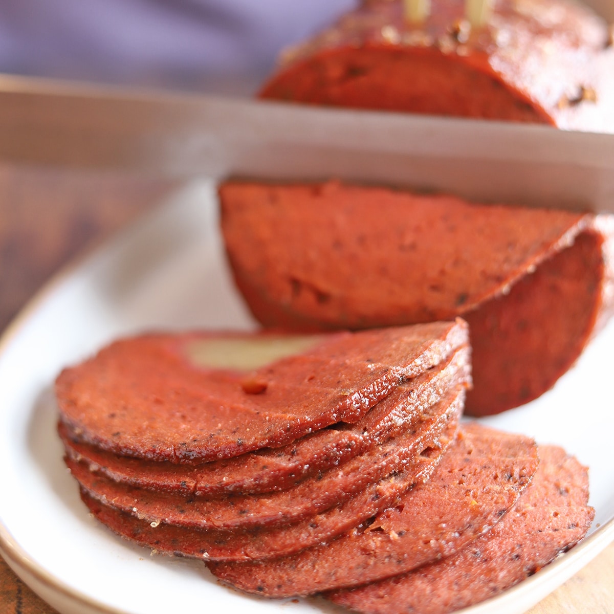 Seitan ham being sliced with knife.