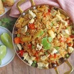 Pineapple fried rice in skillet, topped with eggy tofu.