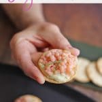 Text overlay: Vegan caviar. Hand holding cracker with almond cheese & pink pearl couscous.