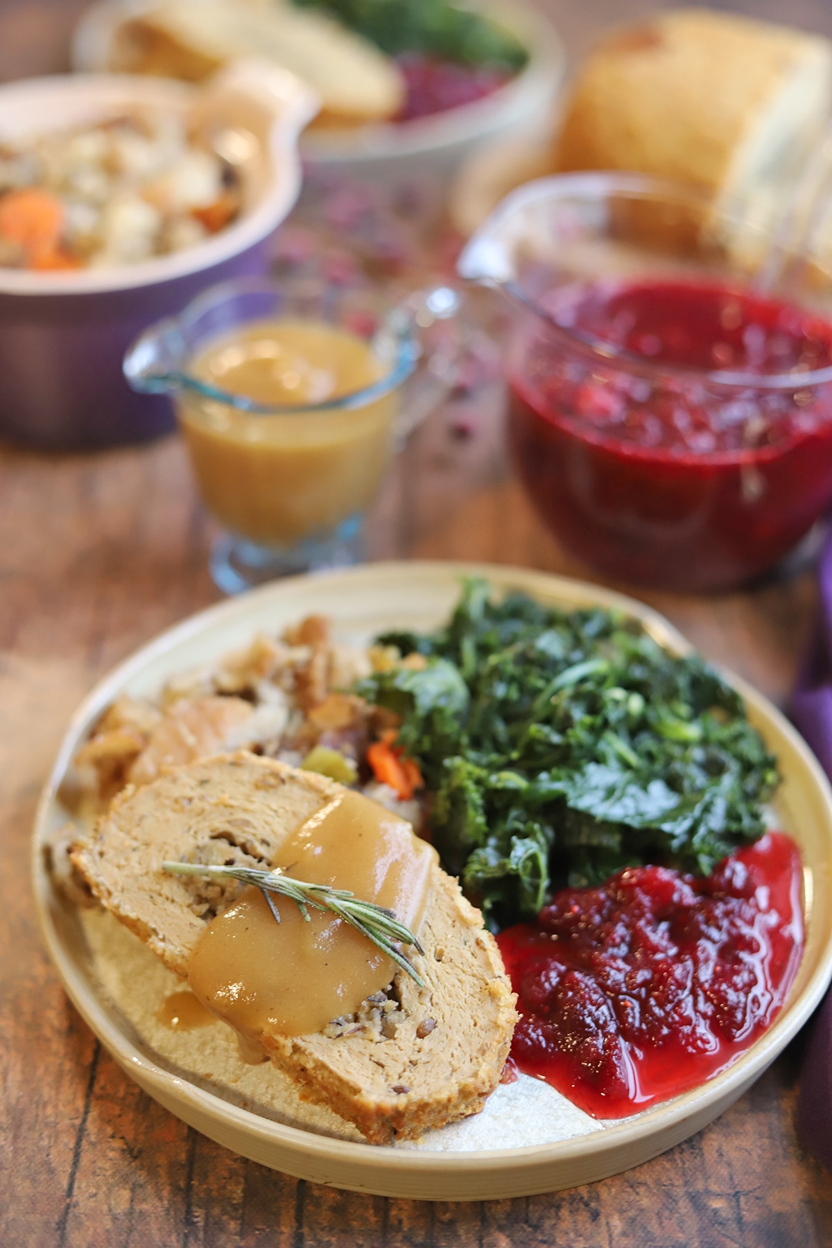 Trader Joe's vegan turkey roast, sauteed kale, and cranberry sauce on plate.
