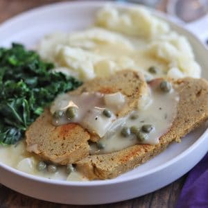 Seitan piccata on plate with kale and mashed potatoes.