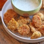Fried pickles on platter with ranch dressing.