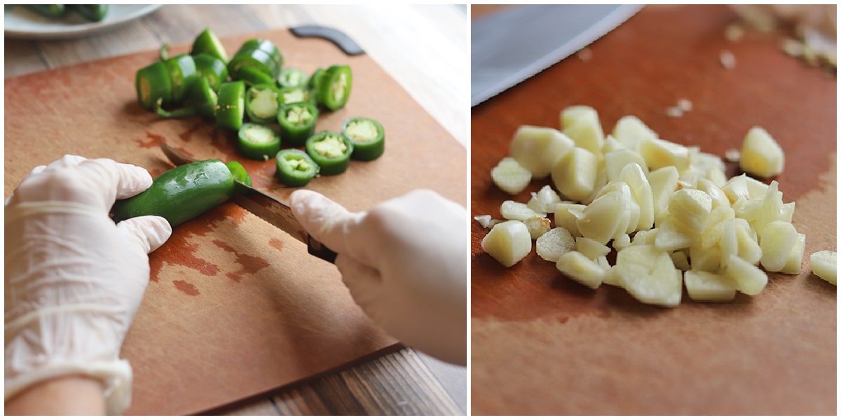 Peppers being sliced on cutting board by sliced garlic.