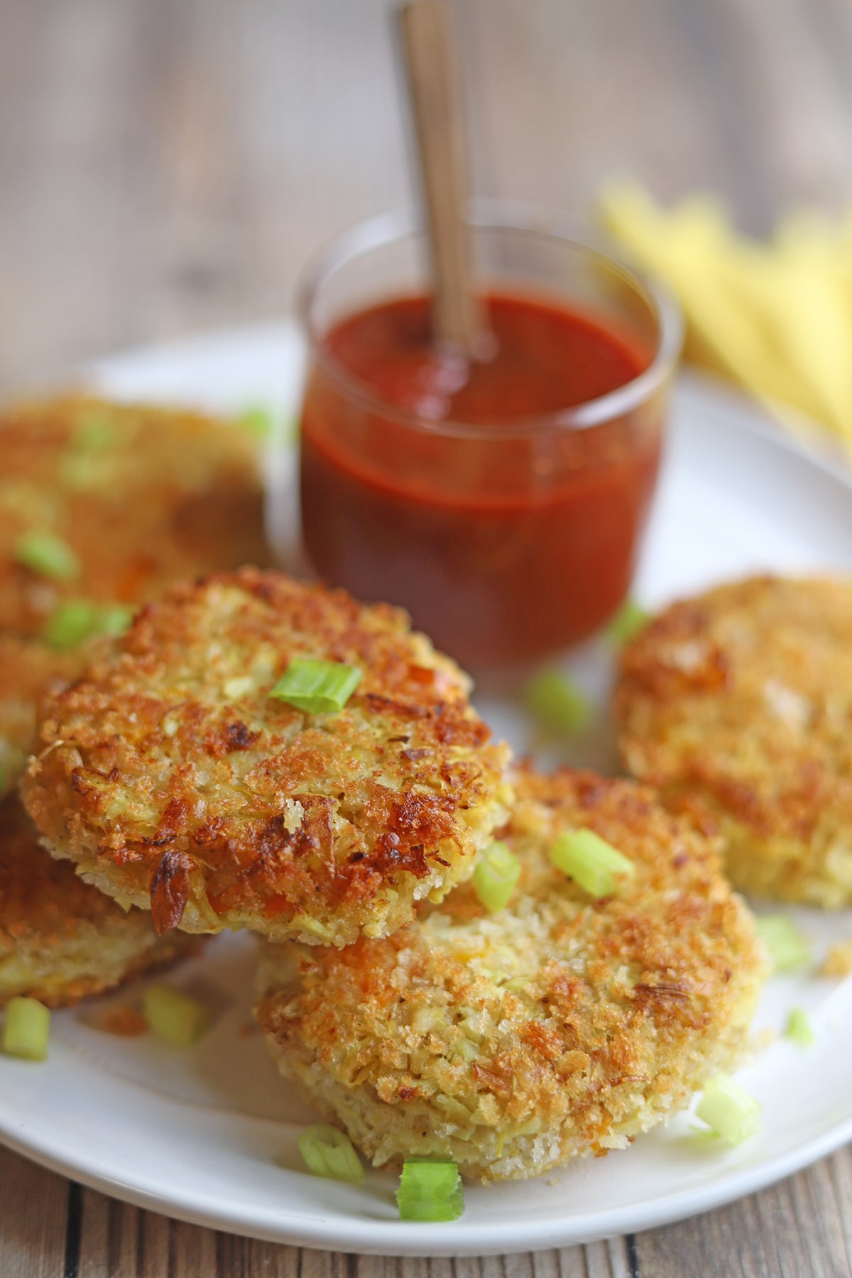 Vegan crab cakes on platter by cocktail sauce.