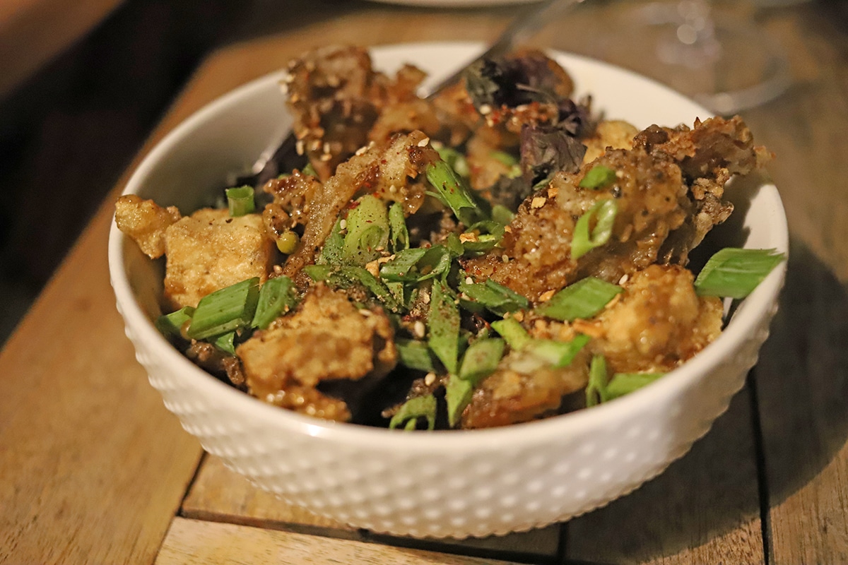 Fried oyster mushrooms with tofu in bowl.