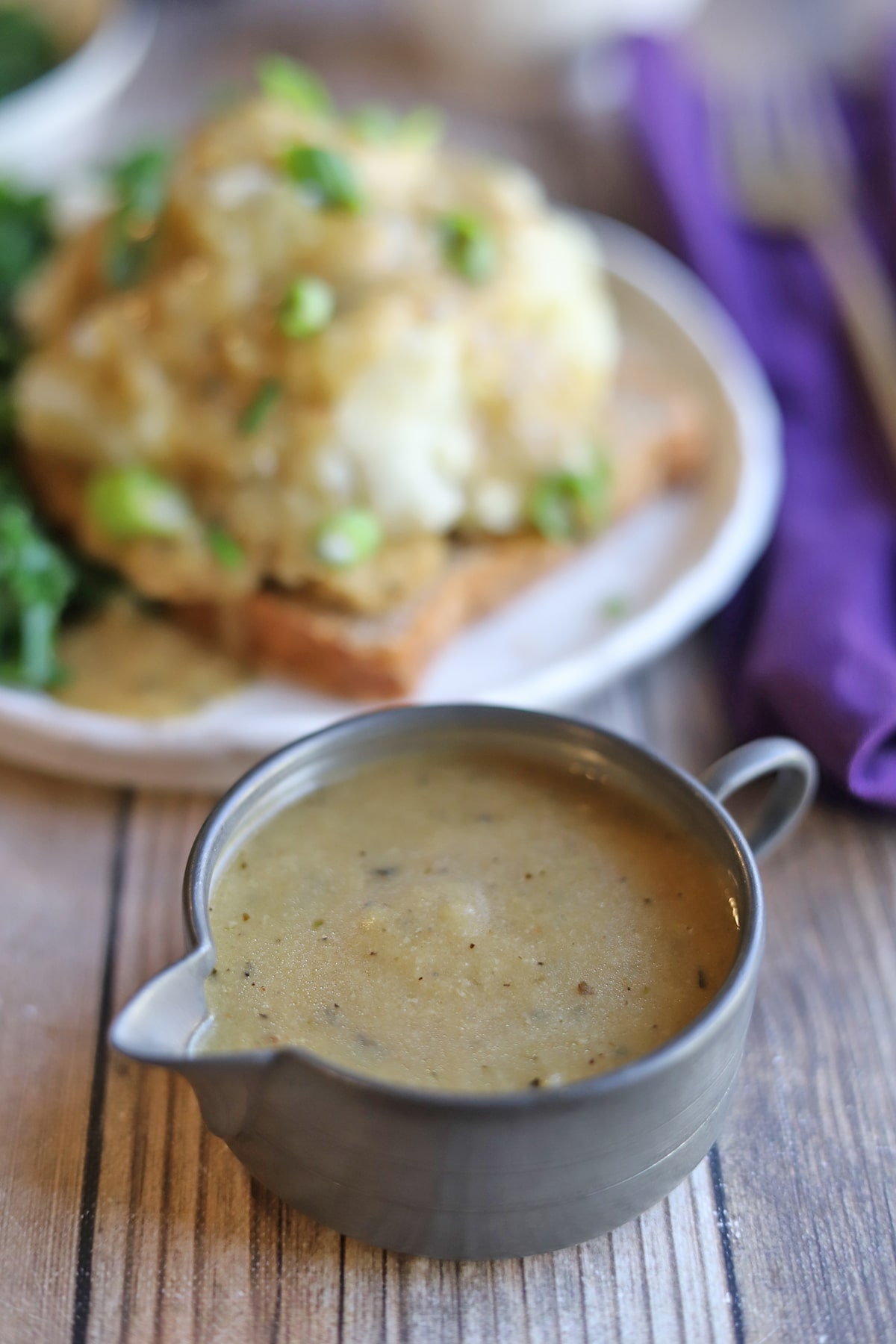 Gravy in small pitcher in front of plate.