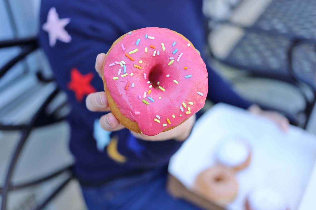 Hand holding pink donut.
