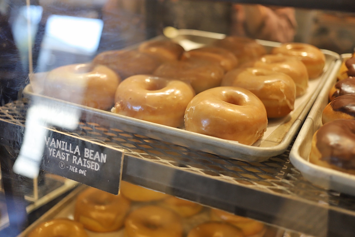Vanilla donuts in display case.