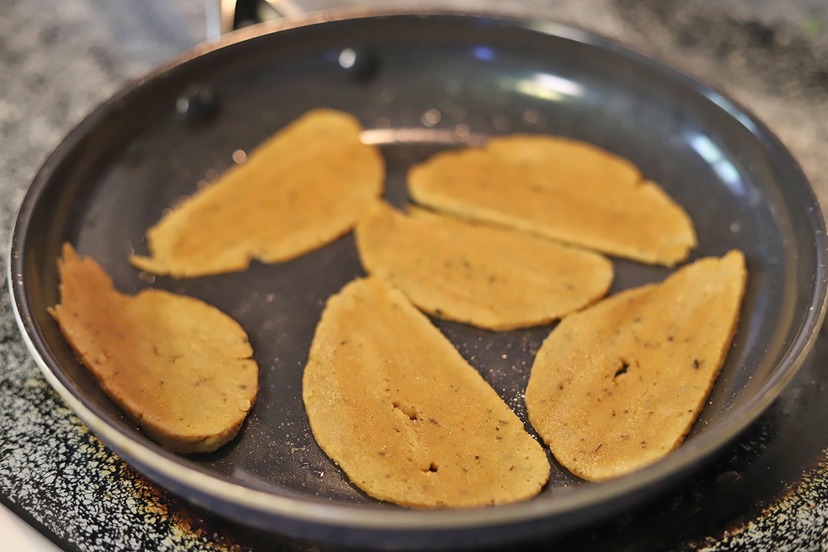 Slices of seitan browning in skillet.