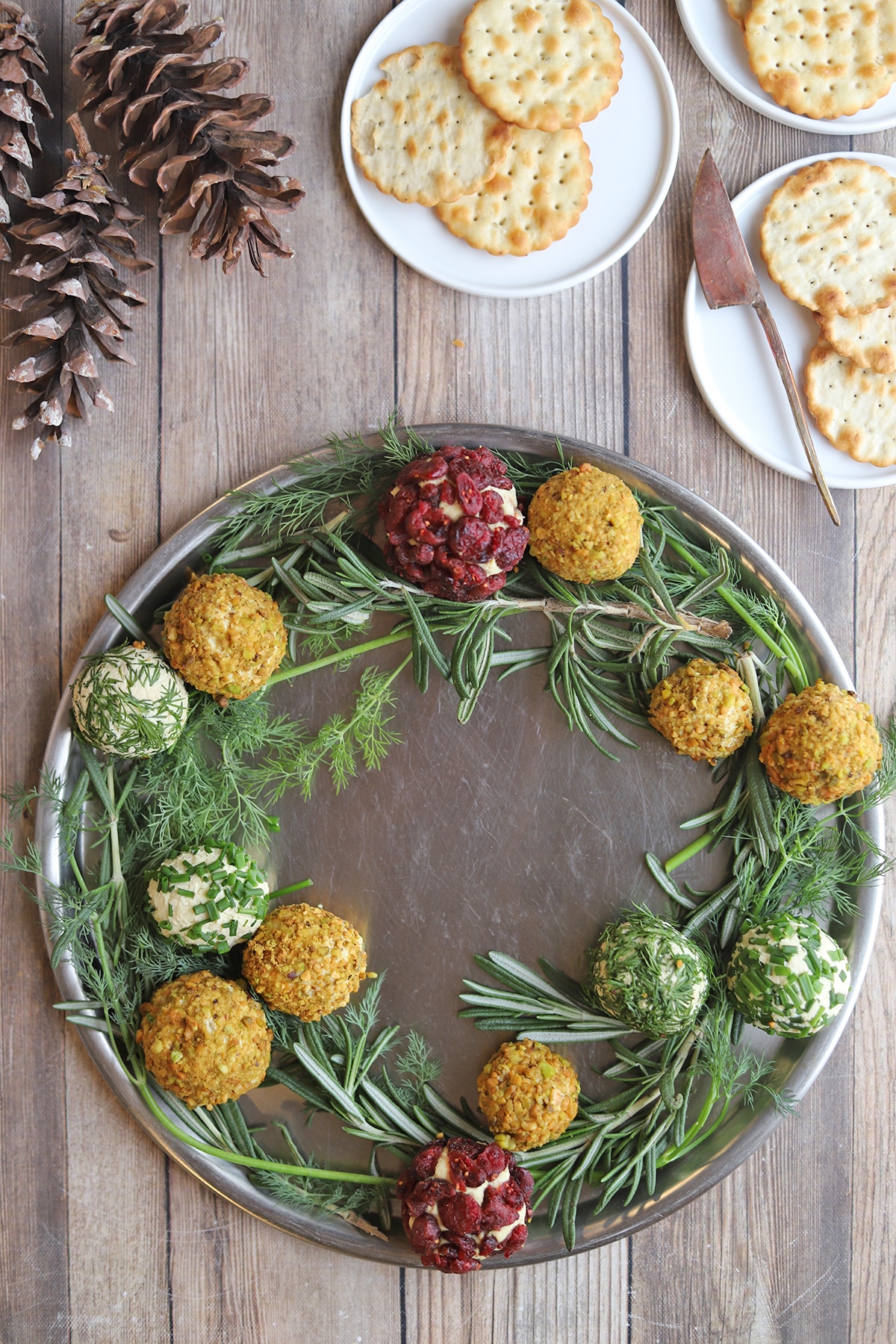 Wreath platter lined with tofu cheese balls on dill & rosemary.