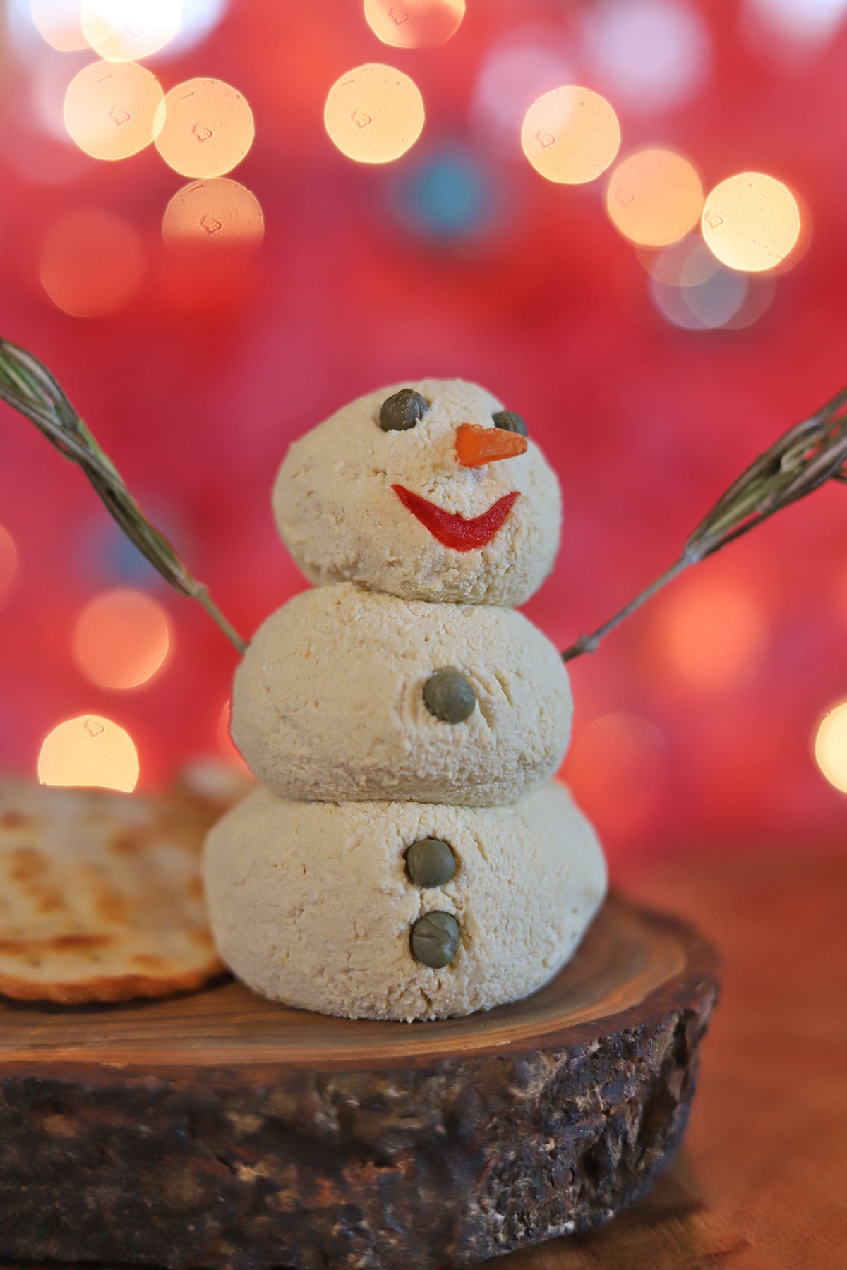 Vegan cheeseball snowman in front of pink Christmas tree.