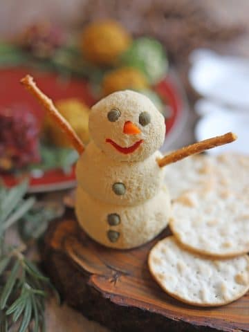 Tofu cheese snowman on table with crackers.