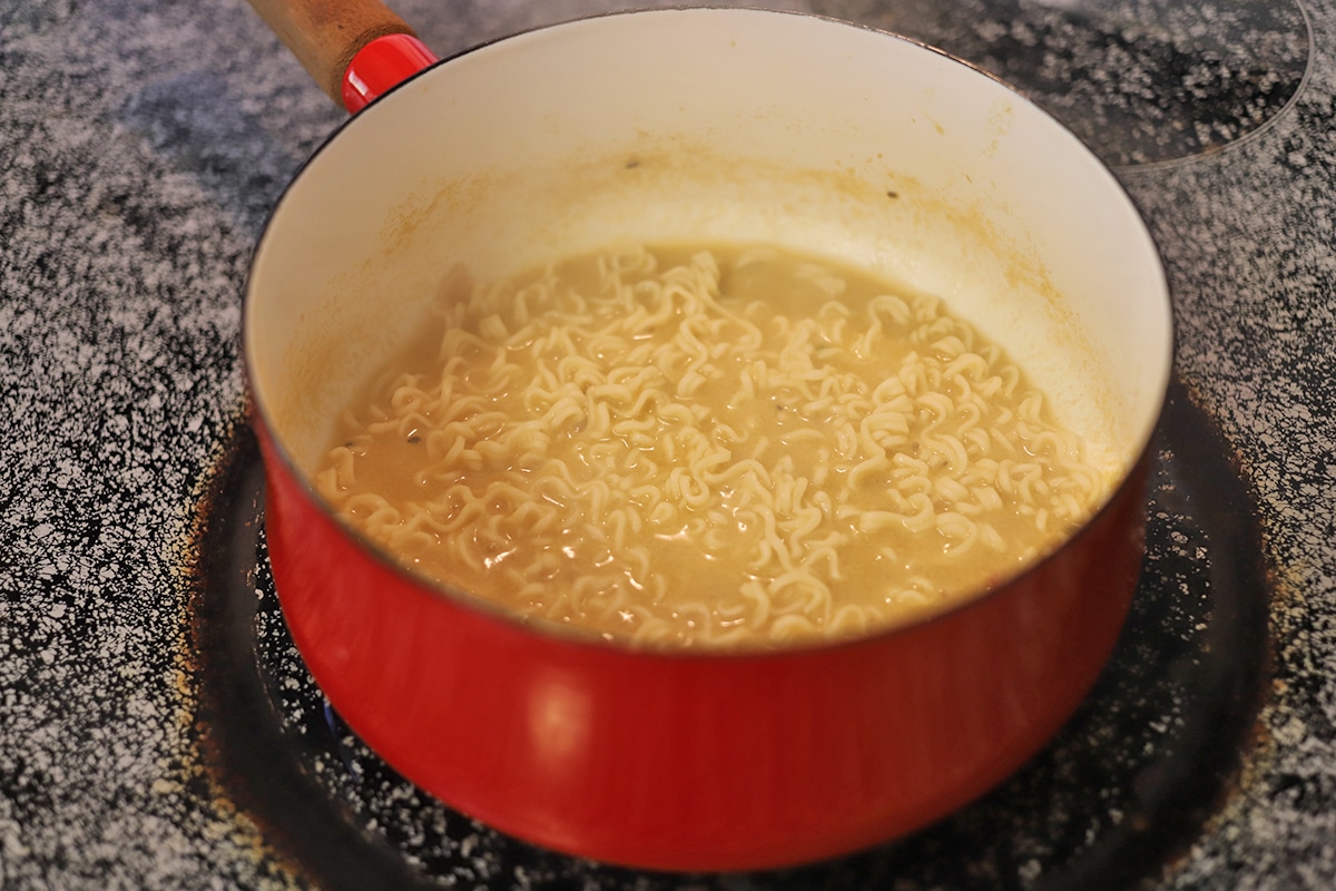 Ramen noodles softening in broth.