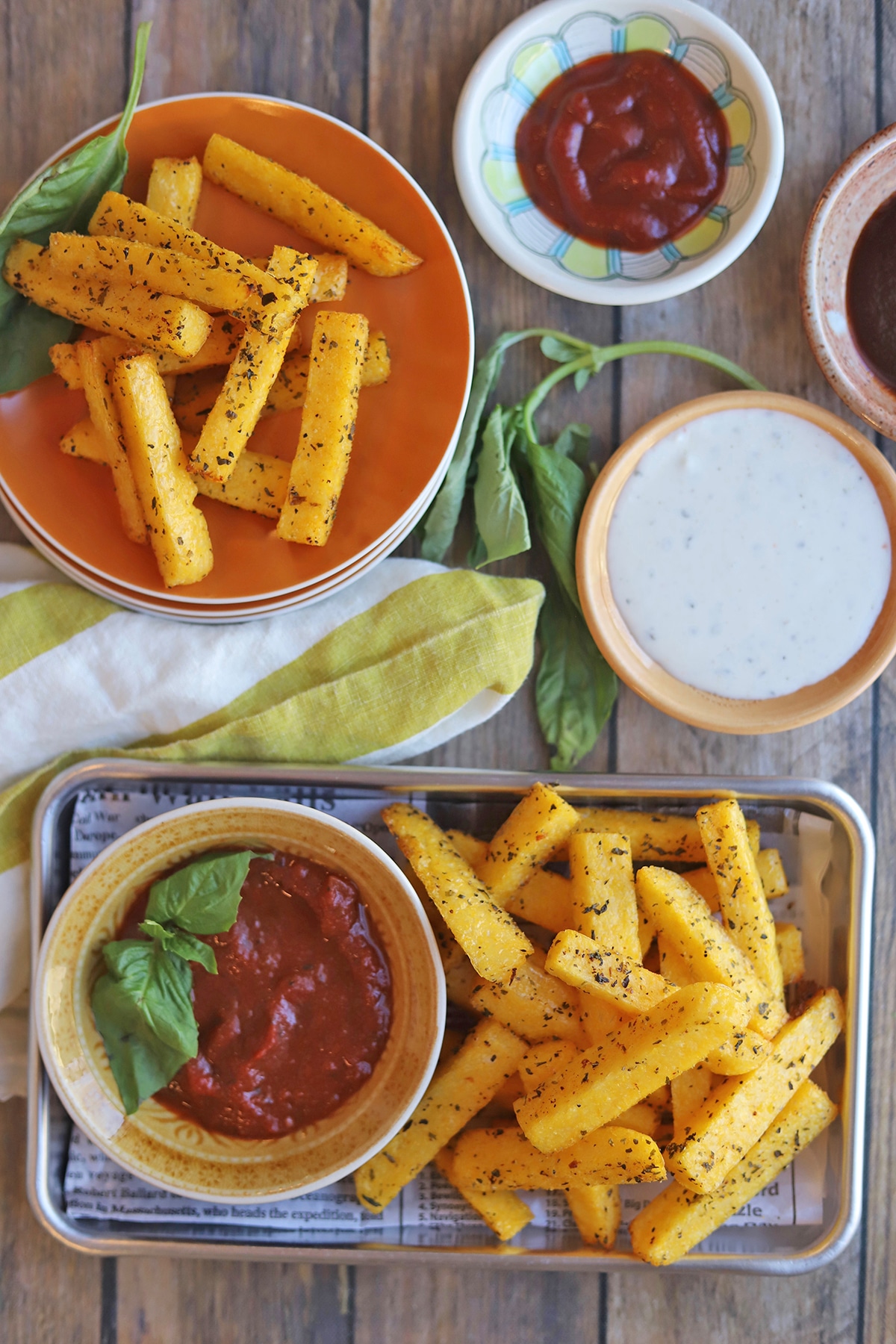 Overhead fried polenta sticks with marinara, ranch, and barbecue sauce.