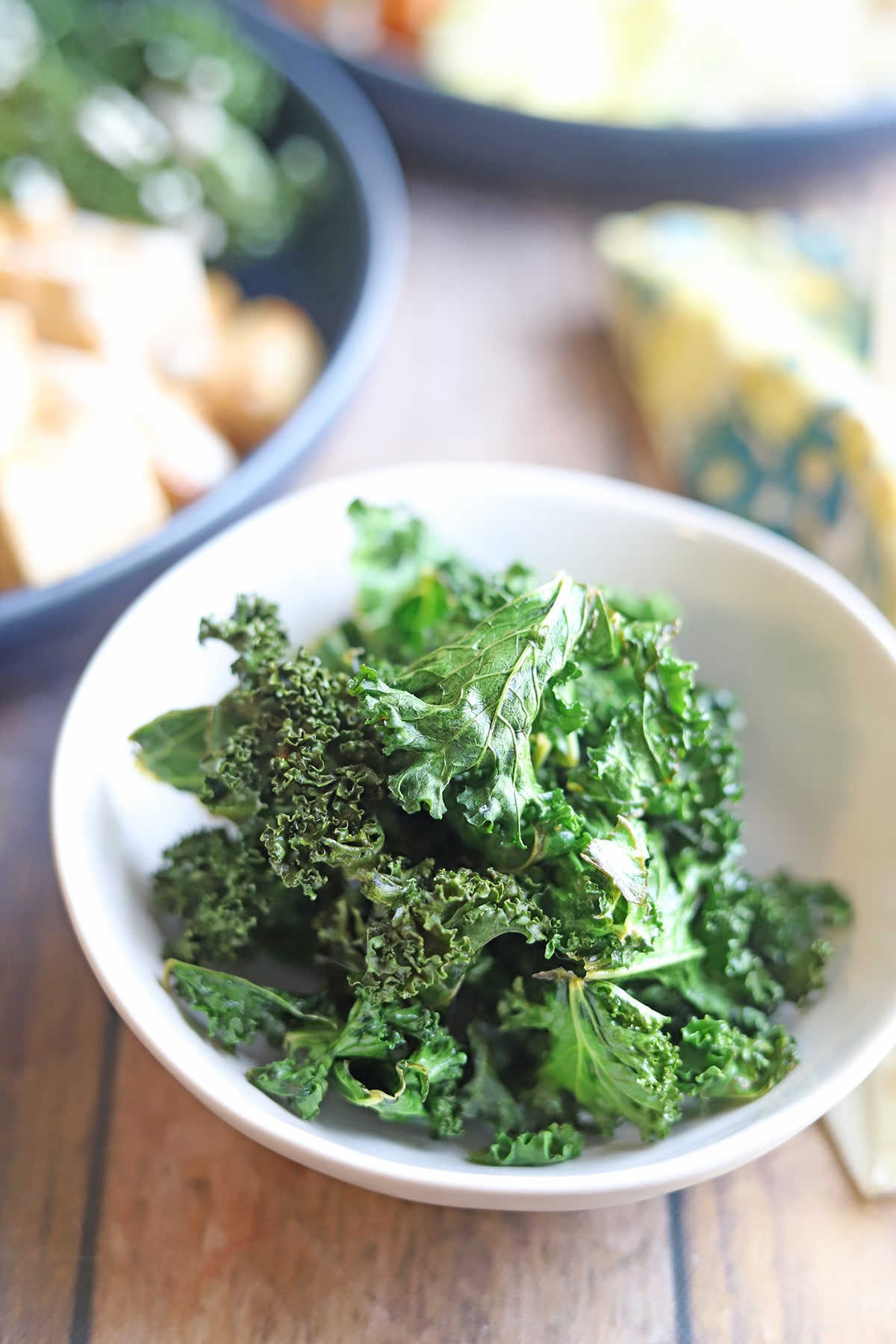 White bowl with crispy kale chips.