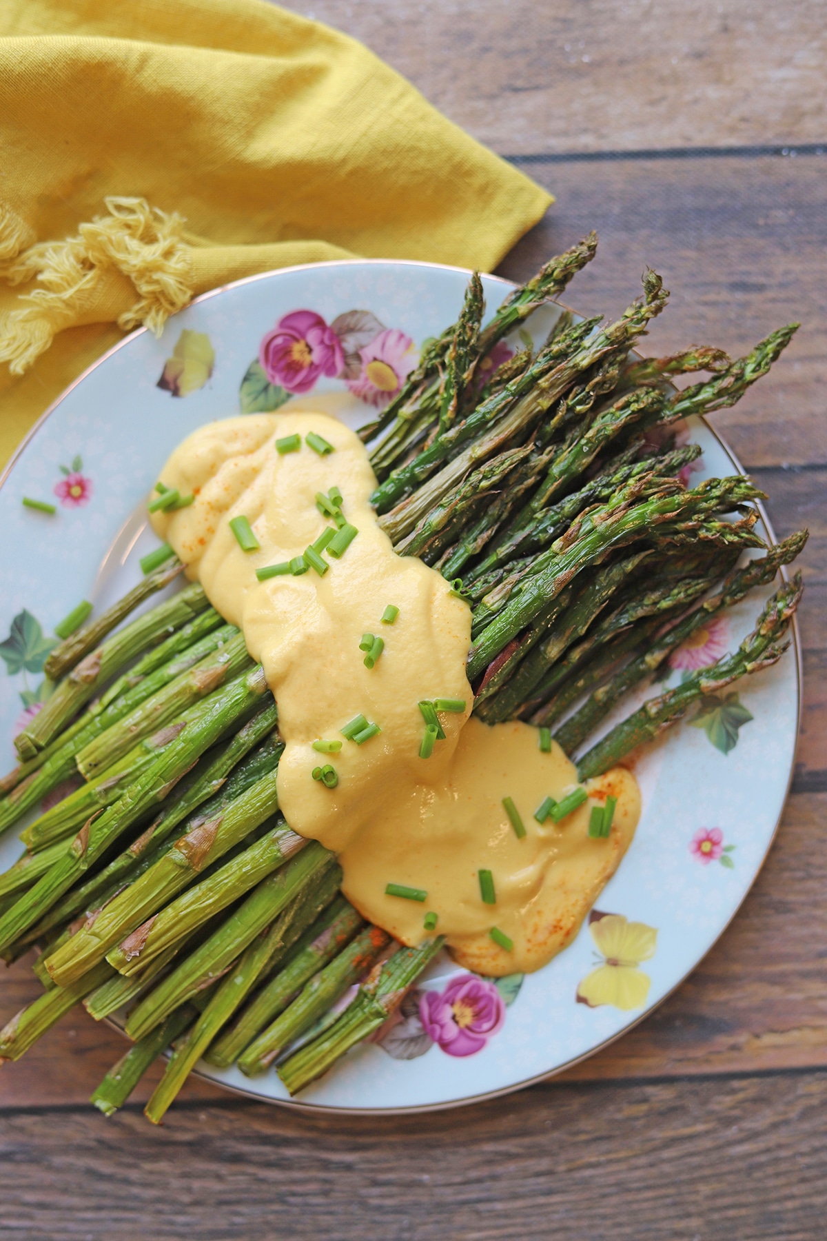 Vegan hollandaise sauce over platter of asparagus.