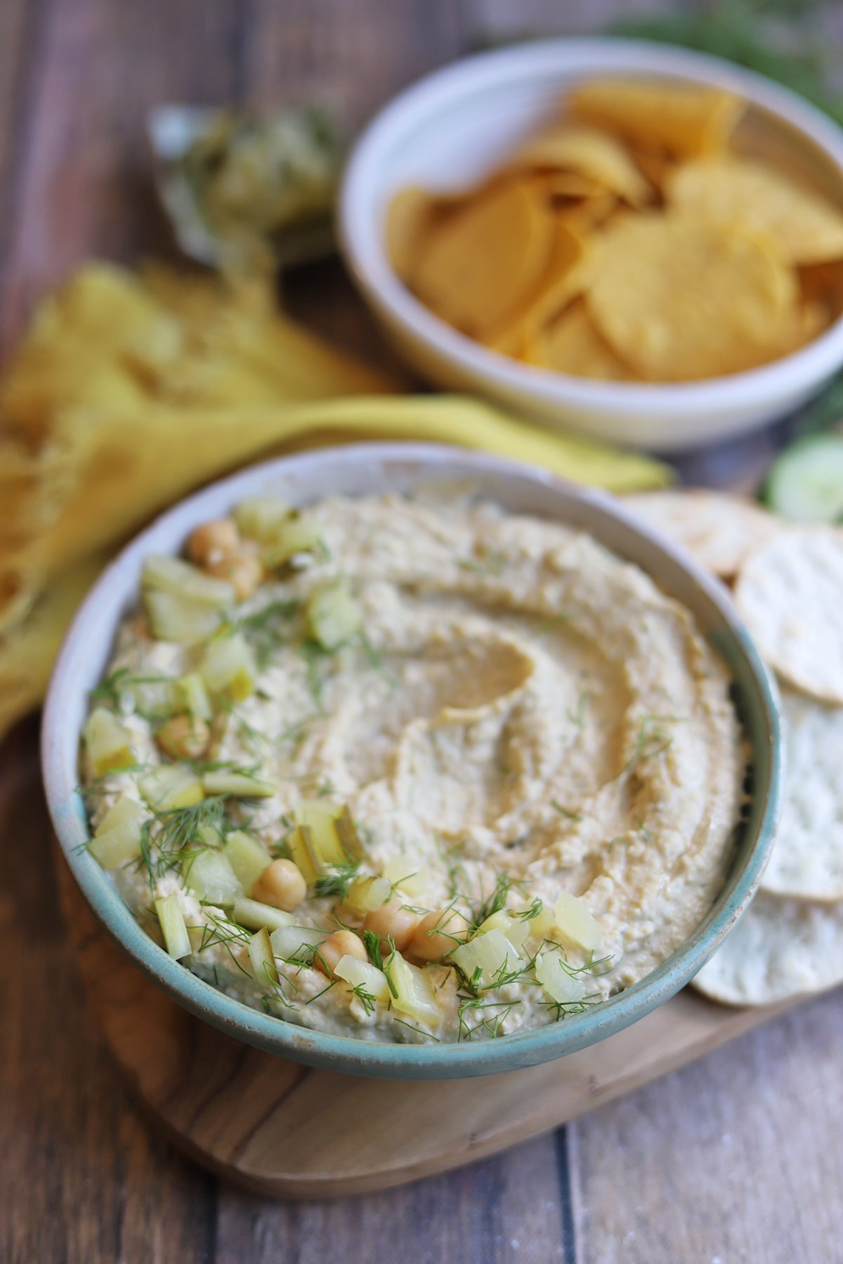 Pickle hummus on table with tortilla chips.